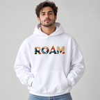 Man wearing white ROAM pullover hoodie with colorful outdoor scenes in the chest lettering, a front pouch pocket and blue jeans.