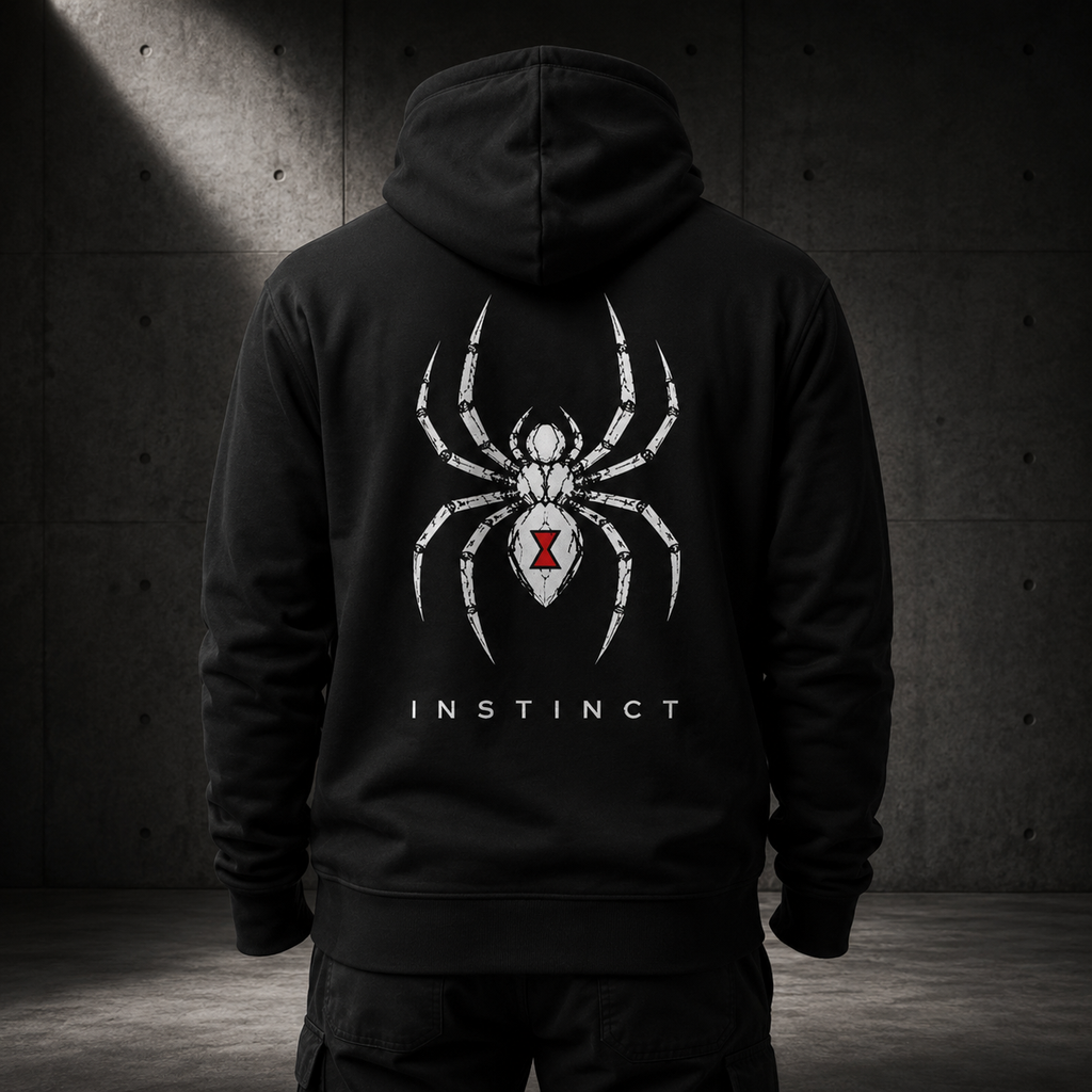 A person shown from the back wearing a black hoodie with a large white spider graphic and the word 'INSTINCT' on the back, standing against a dark concrete wall.